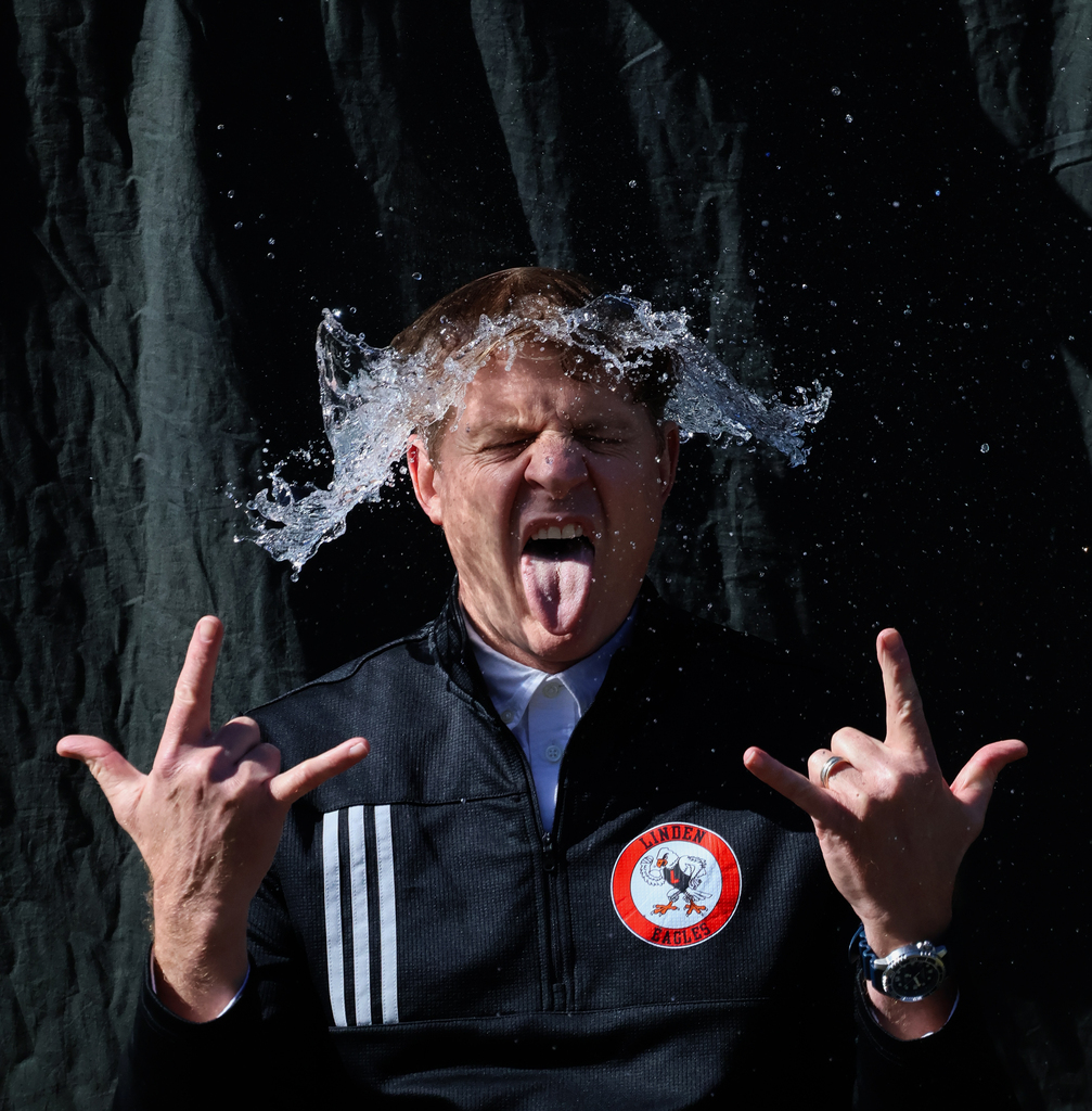 Person with tongue out and water cascading all over them.