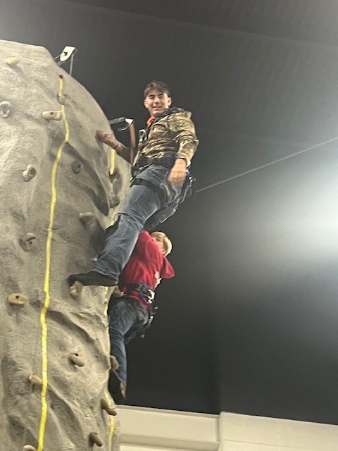 Student at the top of the rock wall