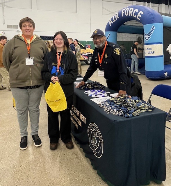 Students standing next to a table with an  MDOC officer 