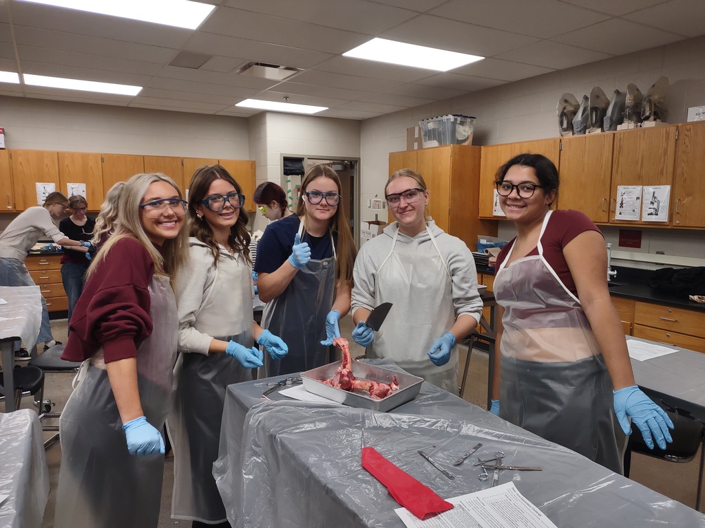 5 students holding deer bone and a saw for the dissection