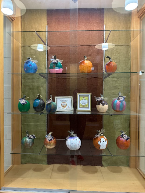 Painted pumpkins in a display case.