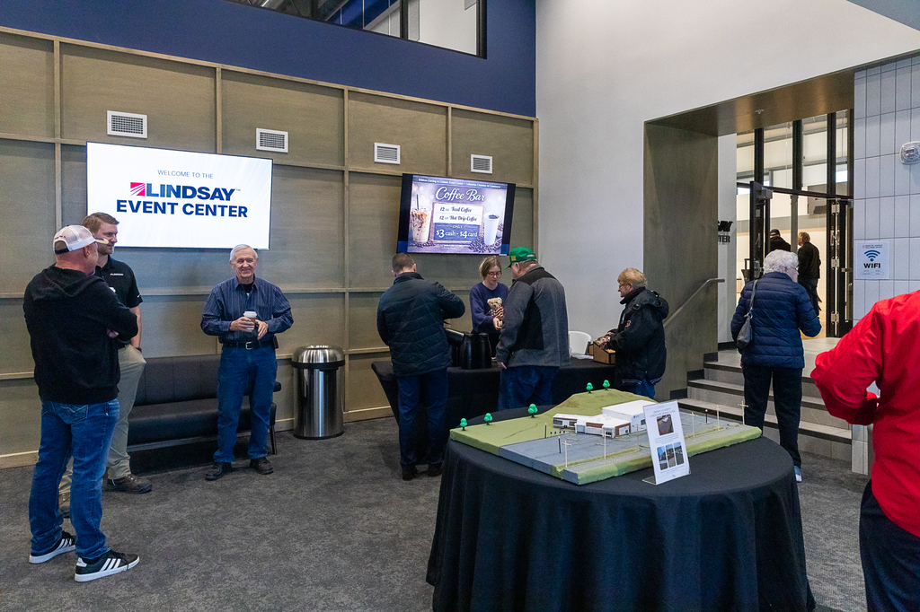 Guests enjoy coffee in the lobby of the Lindsay Event Center during ribbon cutting event.