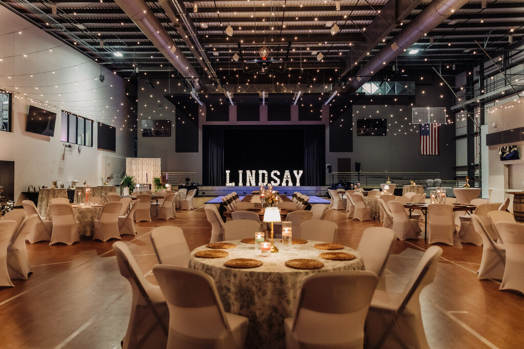 A wide view of the Lindsay Event Center showcasing elegant décor, tables, lighting, and guests during the Grand Reveal.