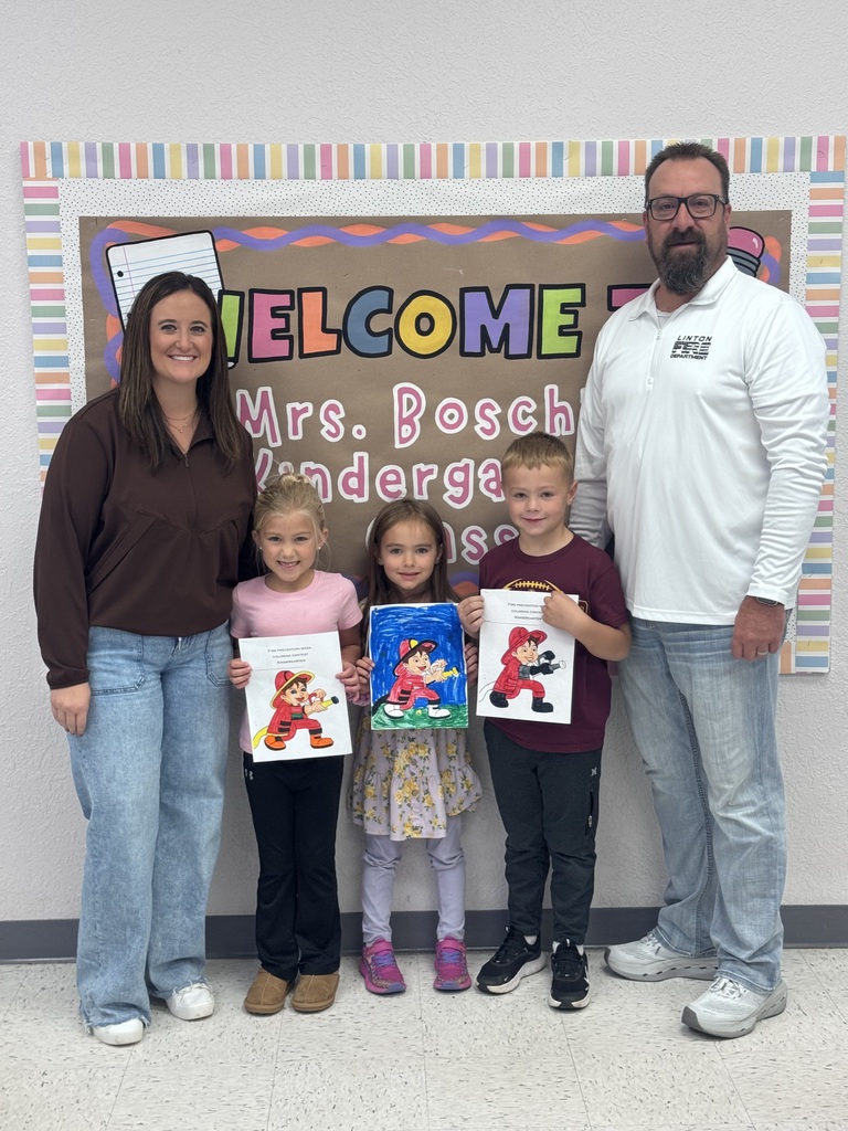 Kindergarten students pose for a class photo recognizing the Fire Prevention Week coloring contest winners. First-place winner Becca Senger, second-place winner Aspen Praus, and third-place winner Jaxon Jochim are recognized. The contest was sponsored by the local fire department.