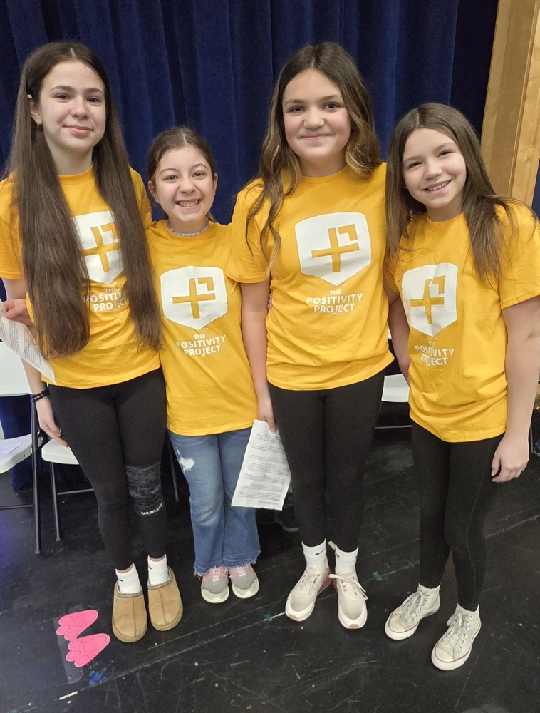 4 students posing in their yellow positivity project shirts