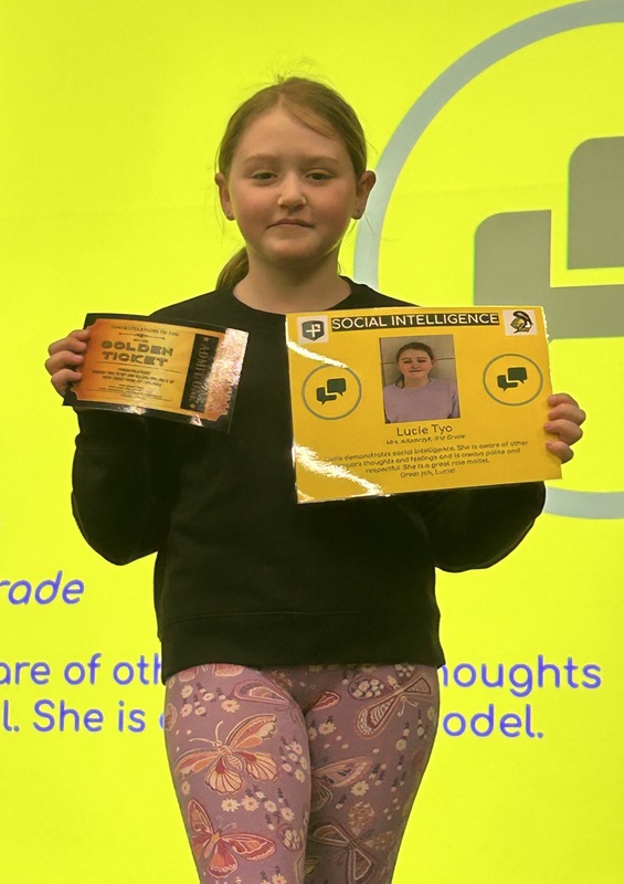 Student posing with their award