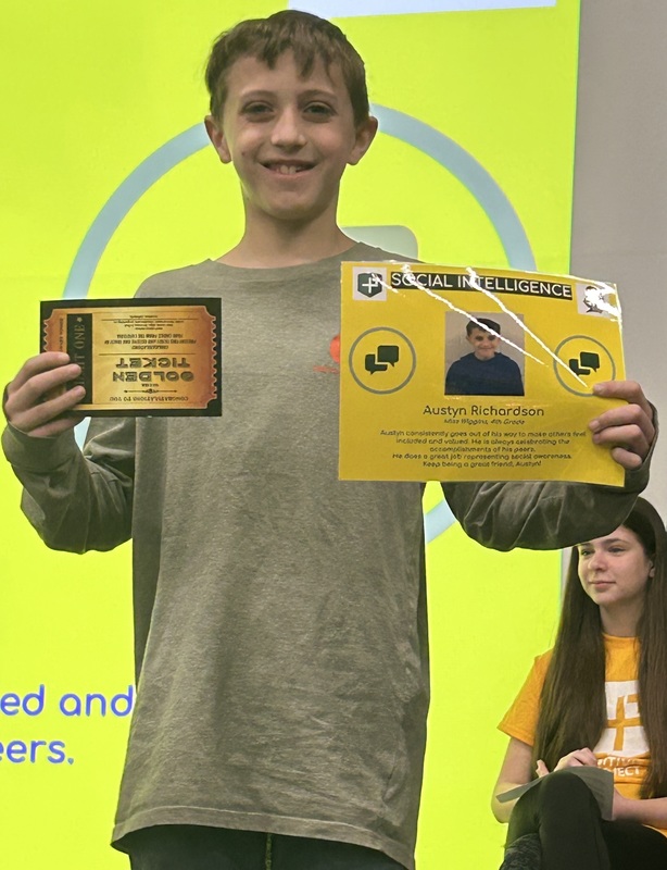 Student posing with their award