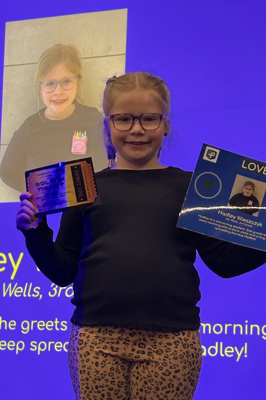 Student posing with their award