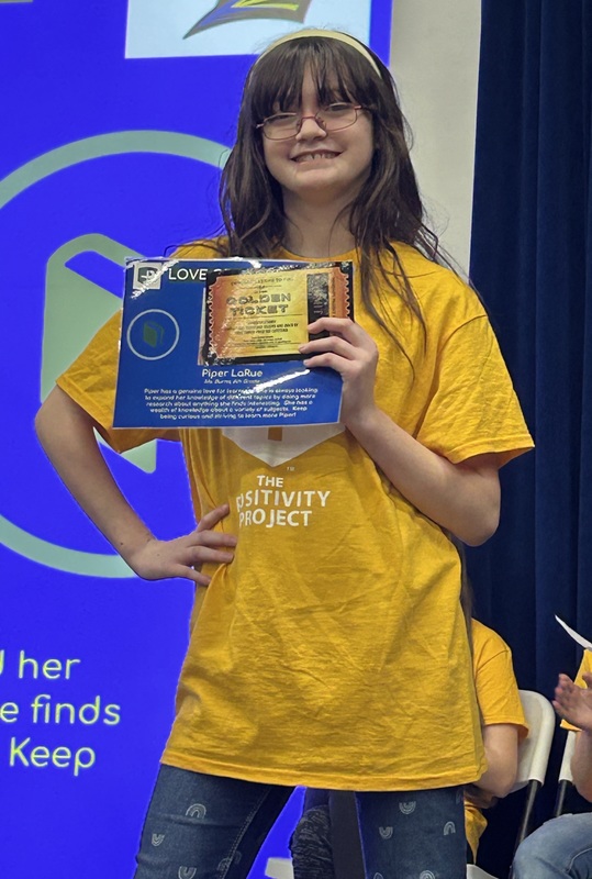Student posing with their award