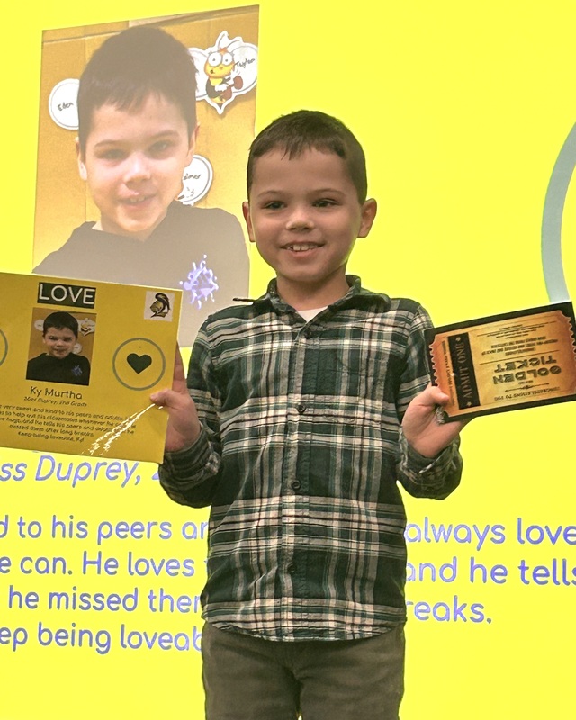 Student posing with their award