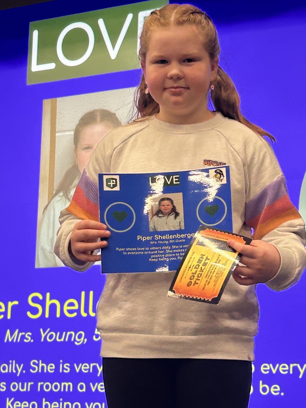 Student posing with their award