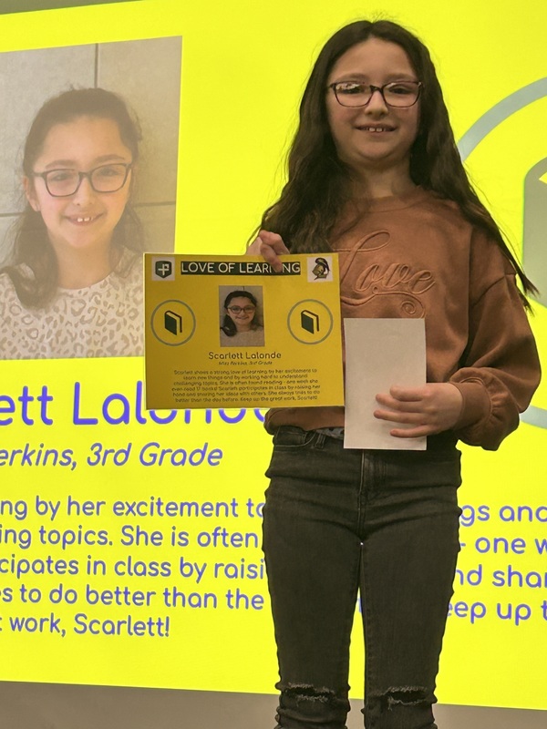 Student posing with their award