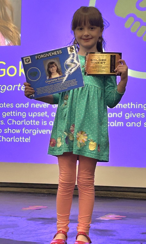 Student posing with their award