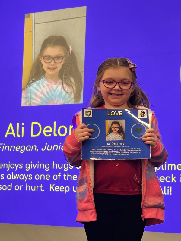 Student posing with their award