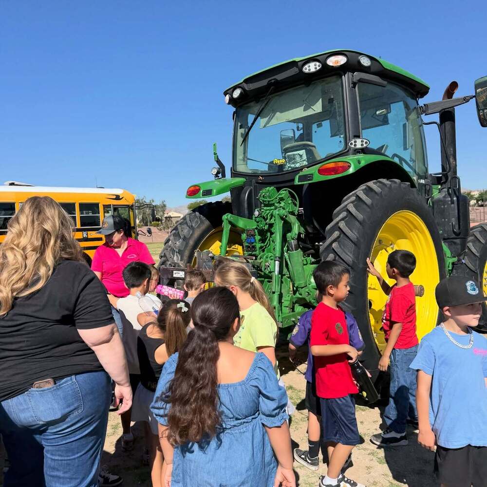 Students look at a large tractor during a career exploration event.