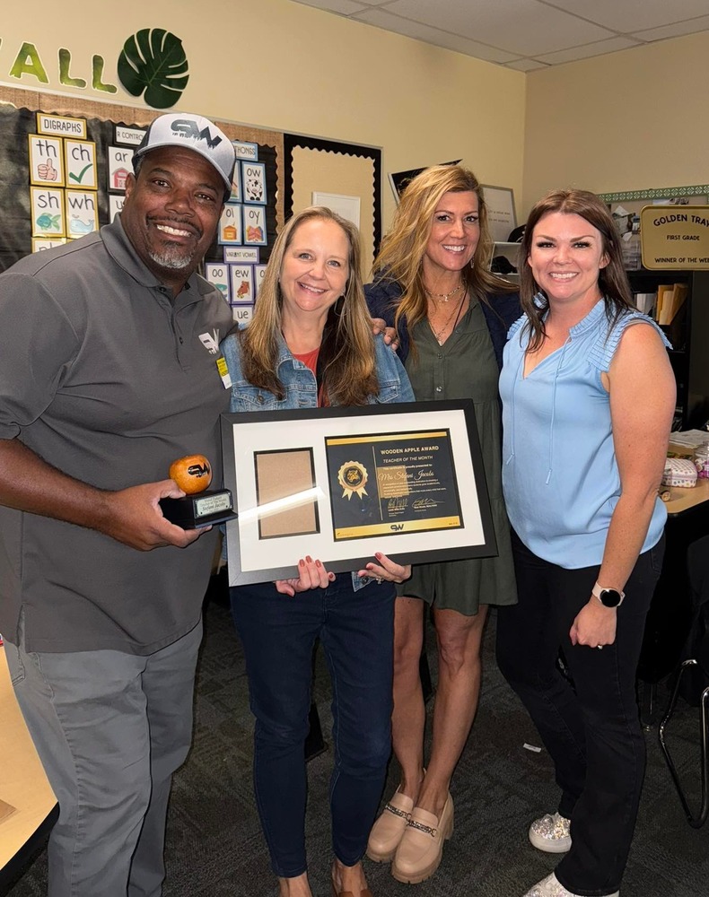Photograph of Mrs. Jacobs, Sean Woods, Principal Willis, and Mrs. Troy