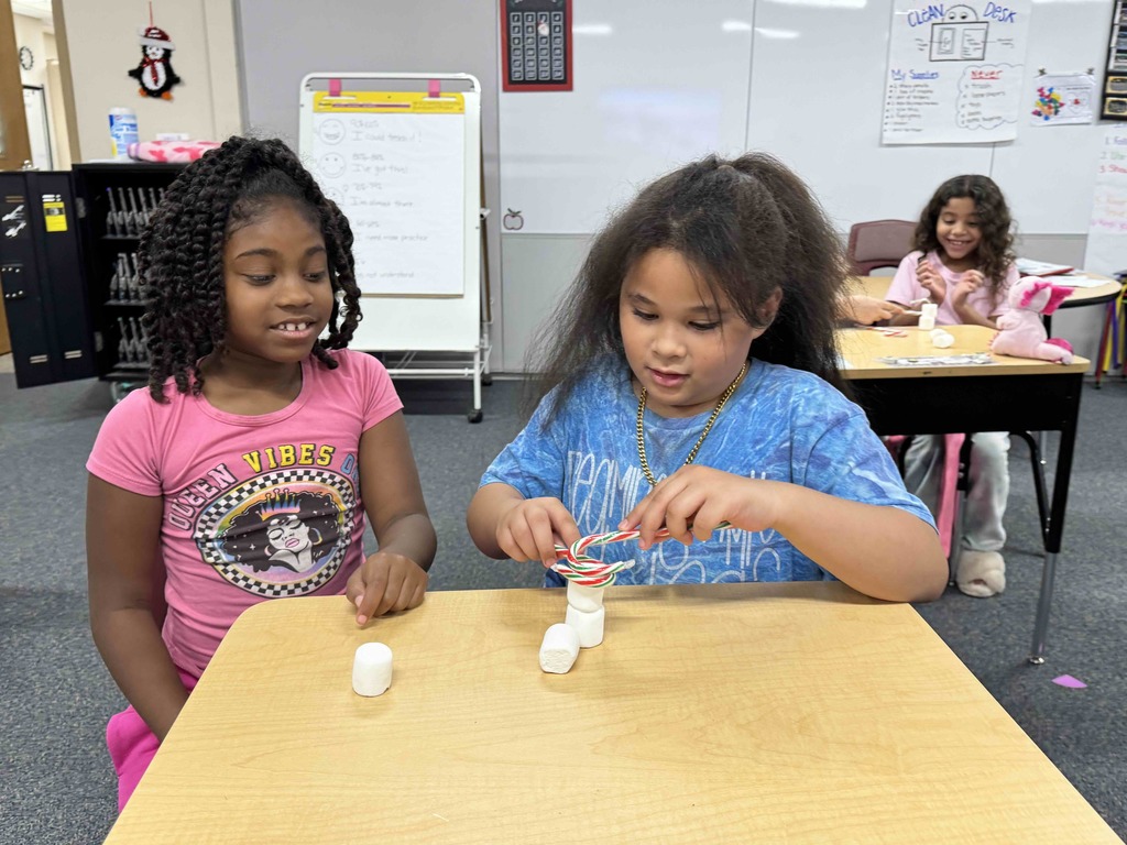 2nd Grade students team building by stacking marshmallows with candy canes. 