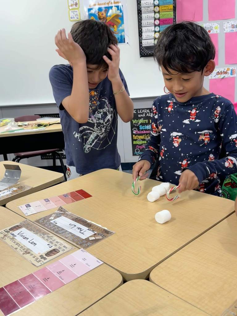 2nd Grade students team building by stacking marshmallows with candy canes. 
