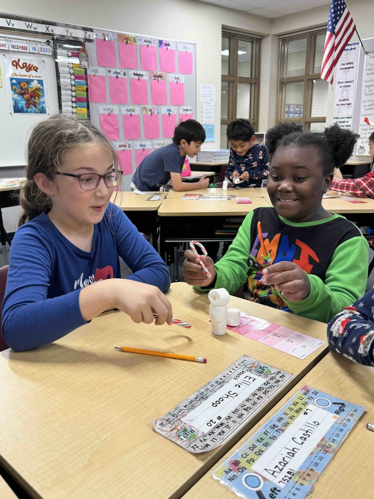 2nd Grade students team building by stacking marshmallows with candy canes. 
