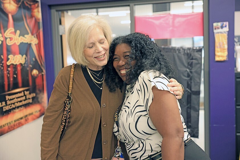 Little Rock Southwest High School Marketing Instructor Renitia Bullard, right, gets a hug from Economics Arkansas Assoc. Dir. Marsha Masters after Bullard was surprised with one of this year's Bessie B. Moore Teaching Awards on Monday, Oct. 26, 2026. The award, presented by Economics Arkansas, recognizes excellence in economics and personal finance education.