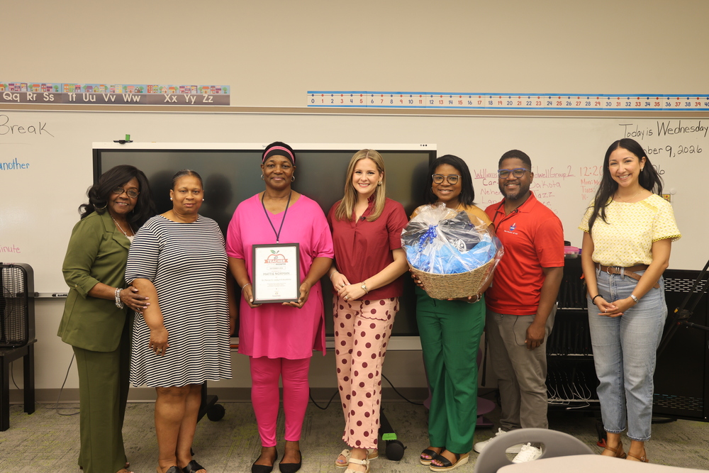 People pose for a picture with Ms. Mattie Norman who won KATV's teacher of the month