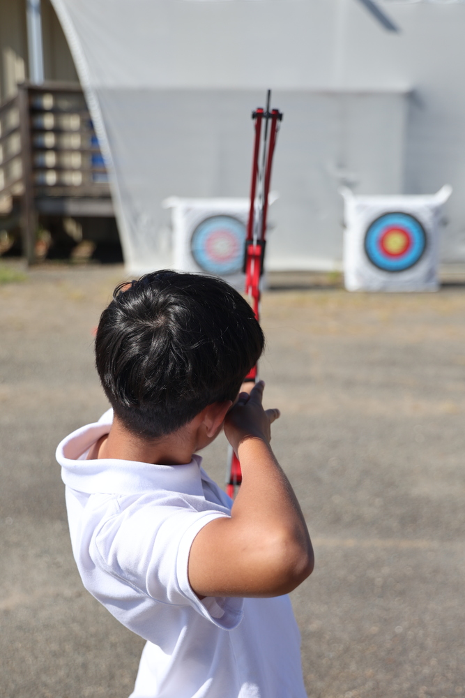 Terry Elementary student aiming a bow and arrow at a target