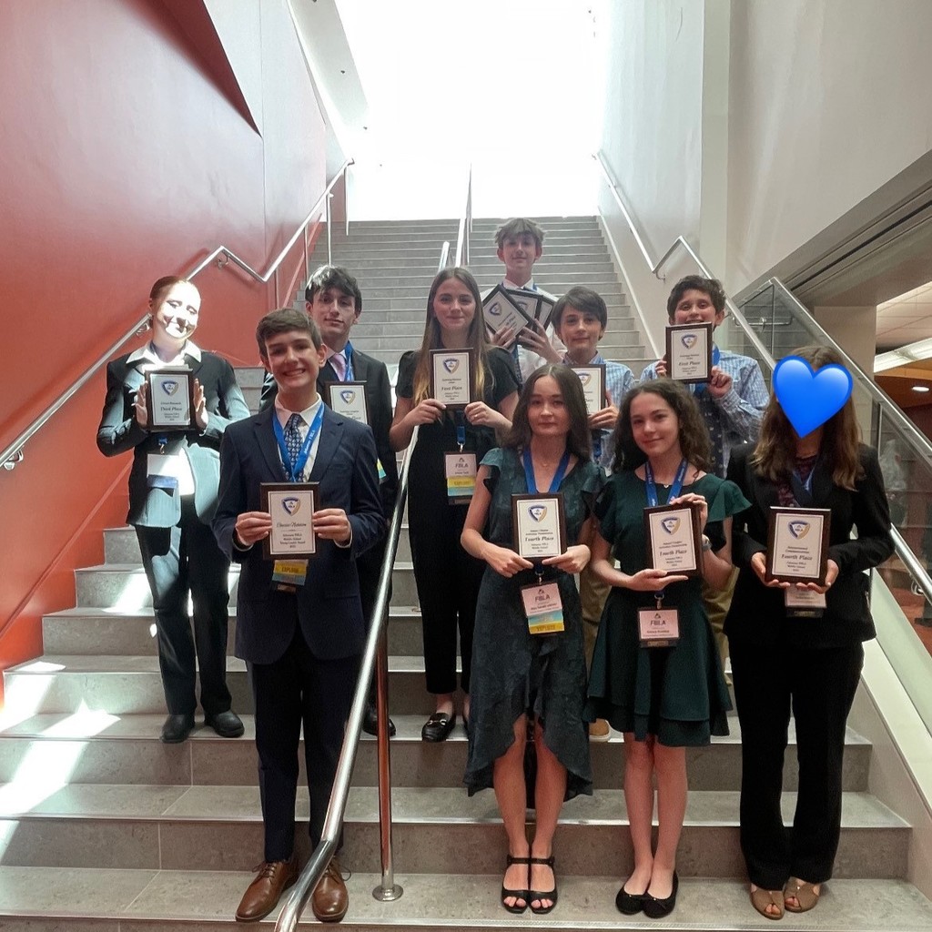 PHMS FBLA students posing with awards on a staircase at state.