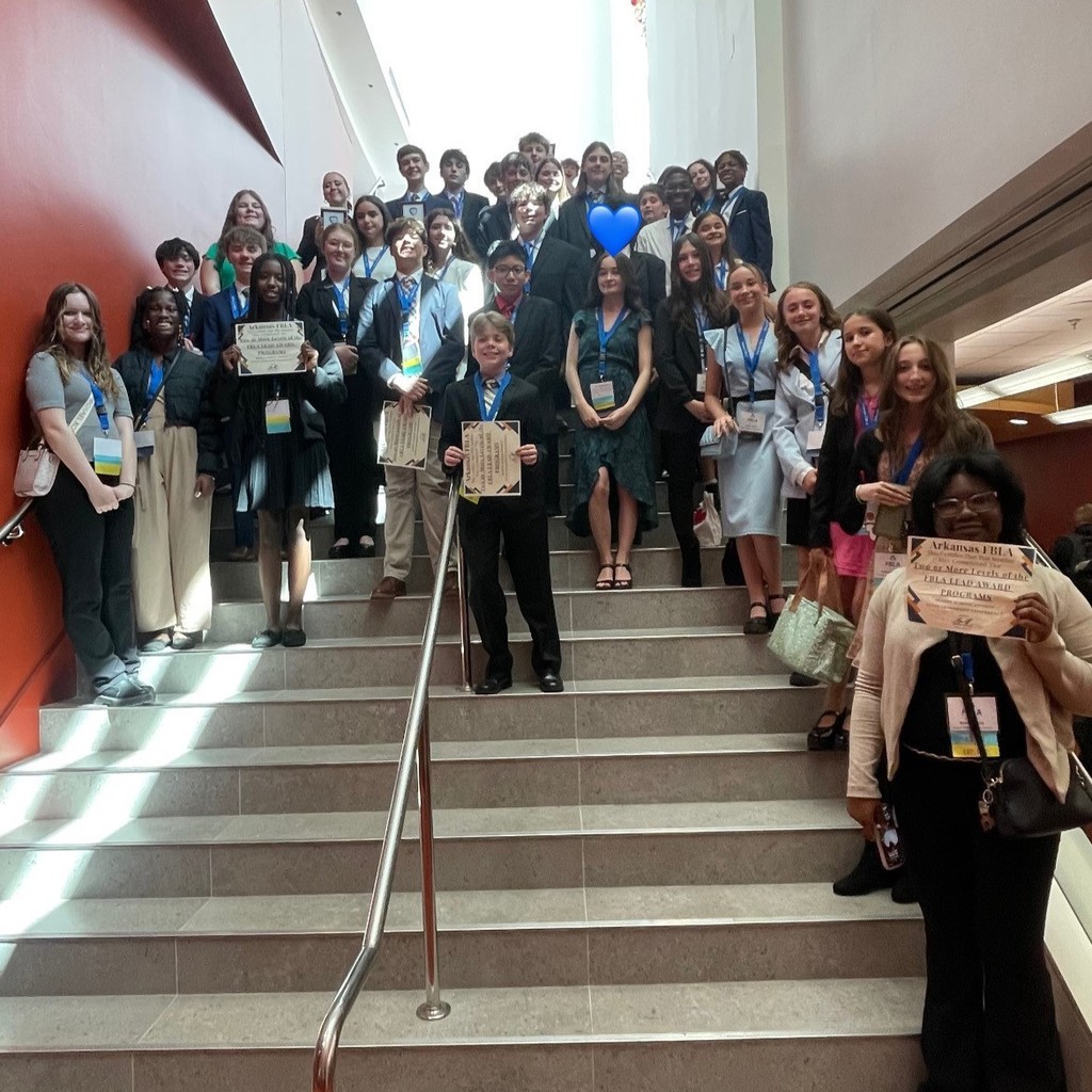 PHMS FBLA students posing with awards on a staircase at state.