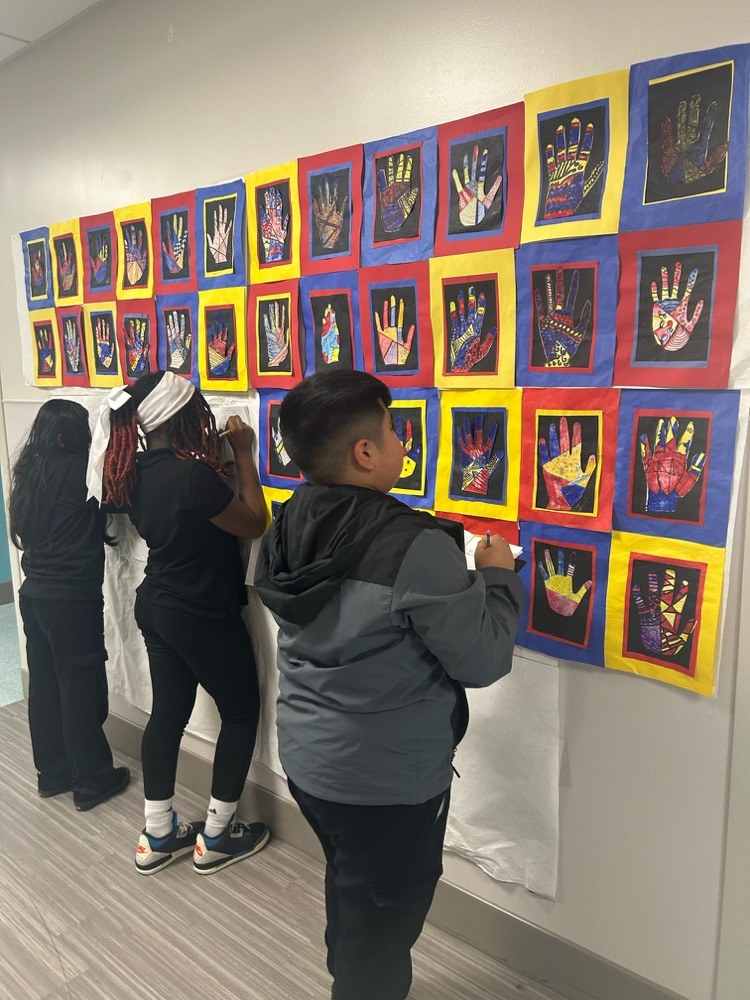 Students are doing a gallery walk of hands in the hallway 