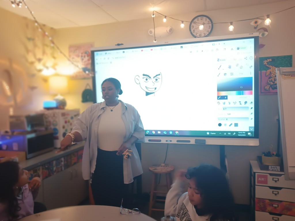 Image of Shannon Wright teachng the art club. 