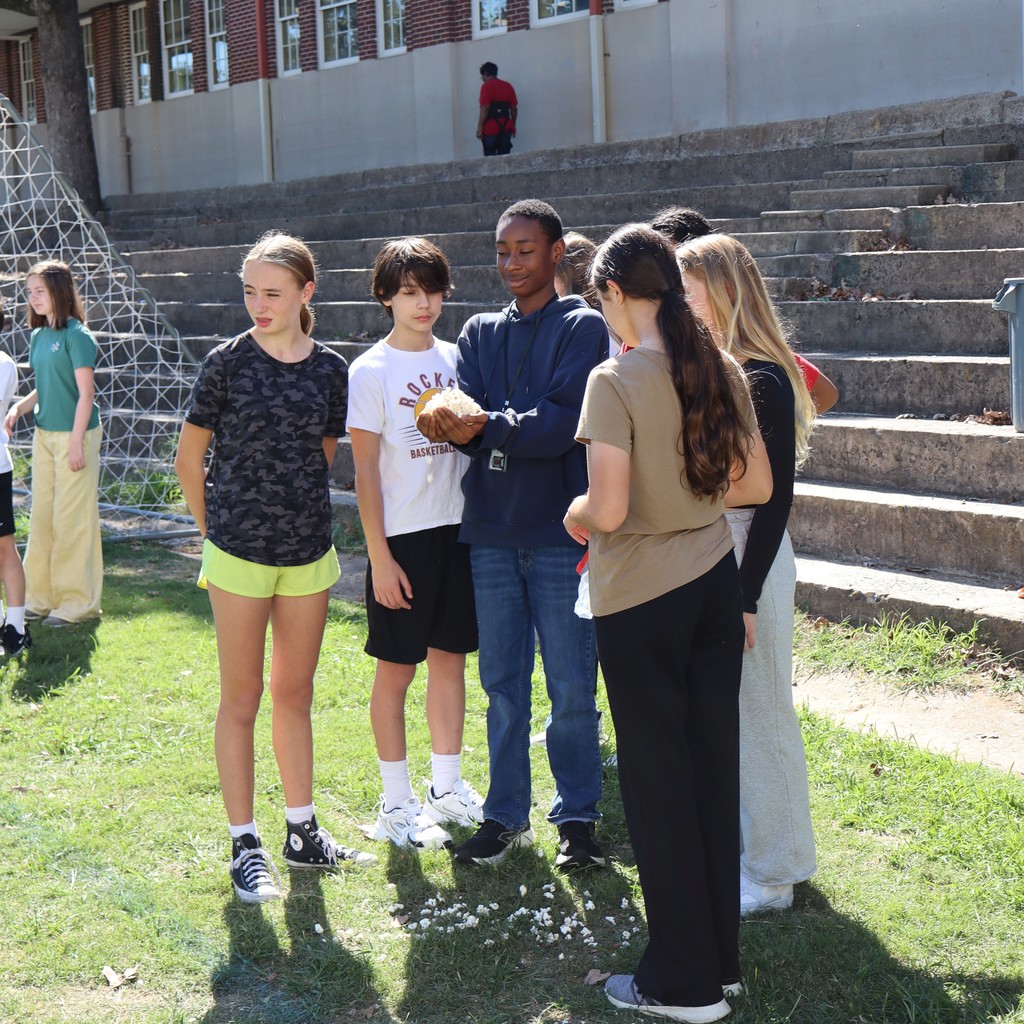 Another student holding popcorn in his hands surrounded by a group.