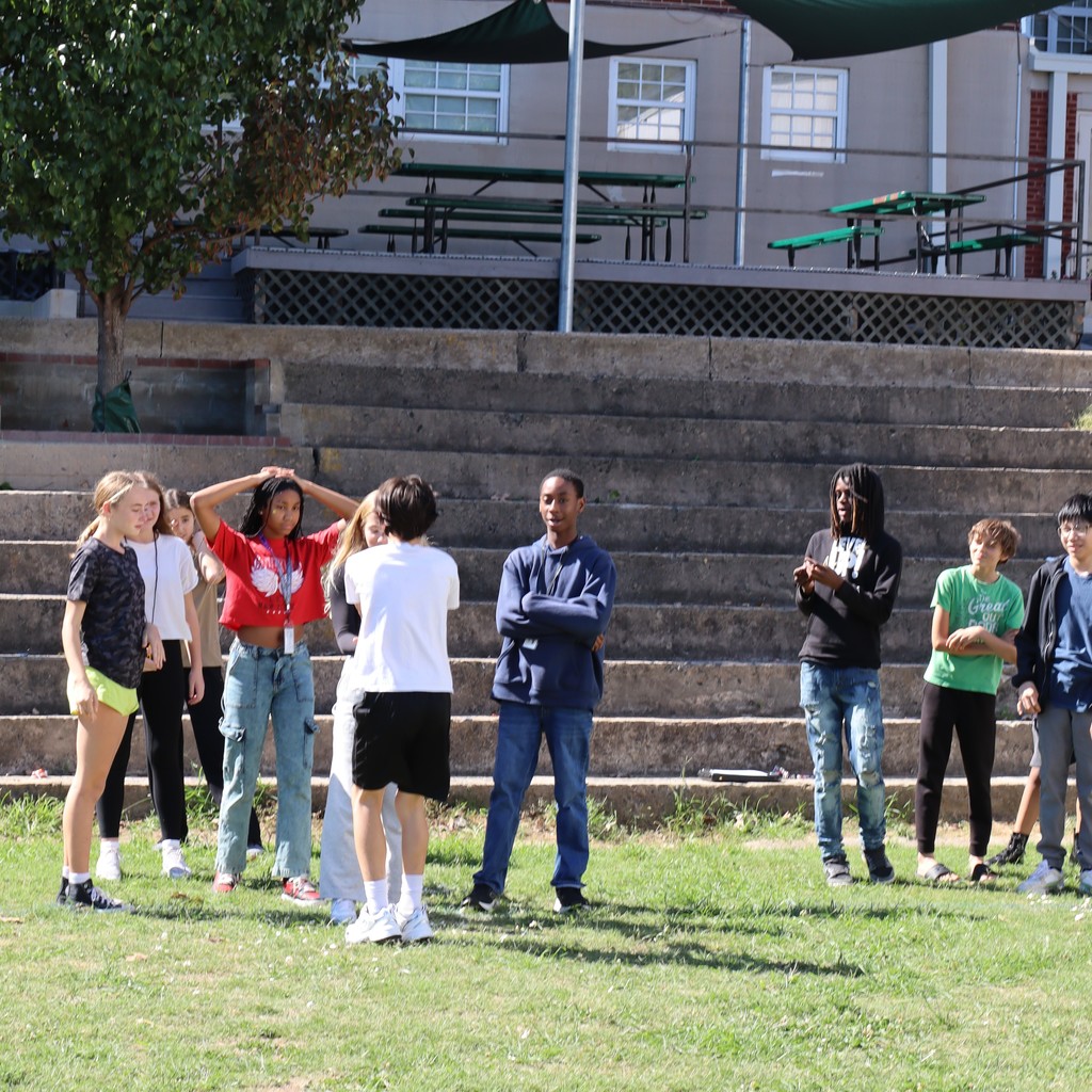 Students grouped together exchanging popcorn between each other.