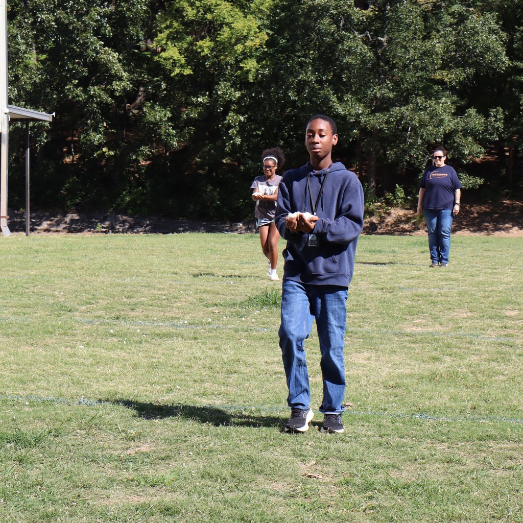Students with handfuls of popcorn participating in a relay