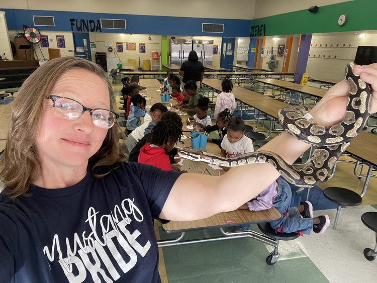 teacher with a snake and students behind her