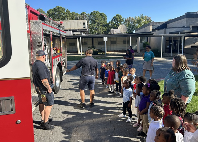 PreK3 Ms. Broadway & Ms. O’Gwin & Ms. Dreher & Ms. Conway’s PreK 3 students watch the firemen explain their community job.