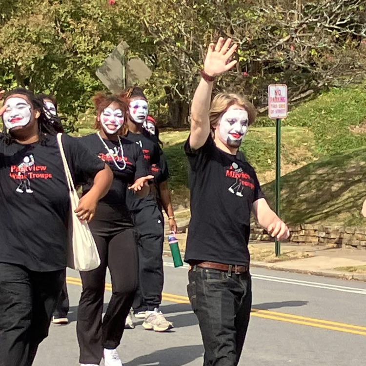 Mimes walking in the street and waving