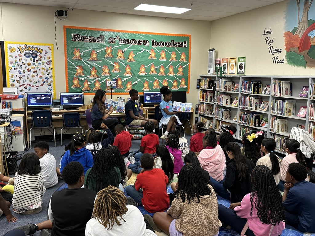 Image of a crowd of Chicot students listening to author Liam Sprinkle, his sister Ella, and their interpreter reading Ella the Banker in English and in Spanish.