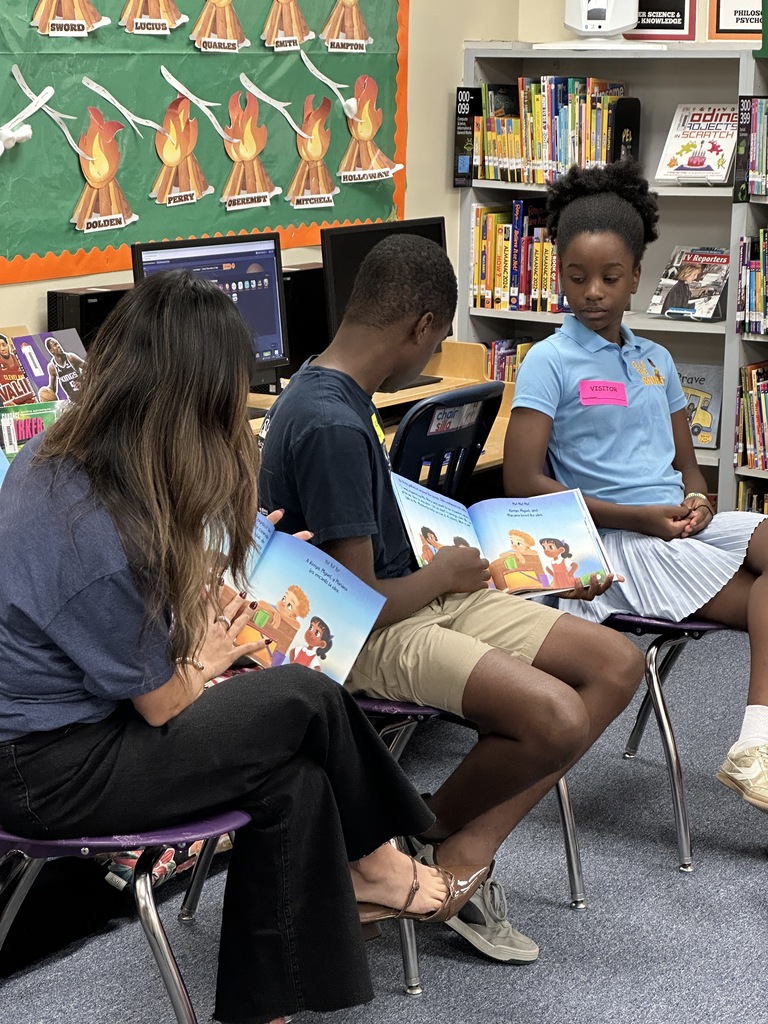 Image of author Liam Sprinkle, his sister Ella, and their interpreter reading Ella the Banker in English and in Spanish.