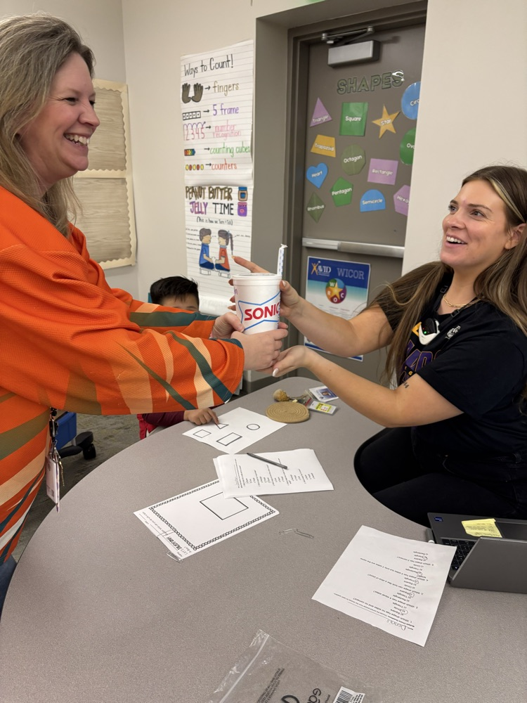 A teacher is being handed a sonic drink