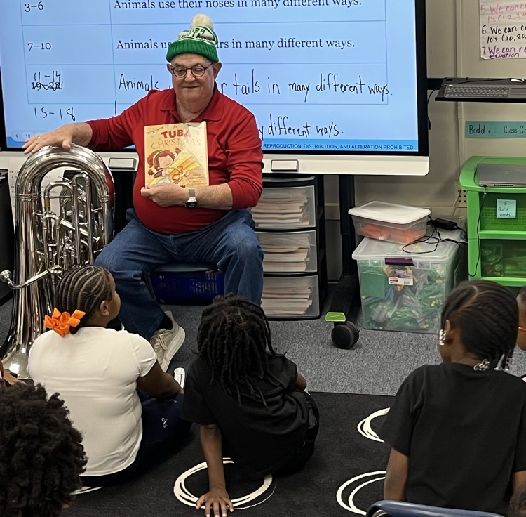 Vokunteer seated in front of students to read
