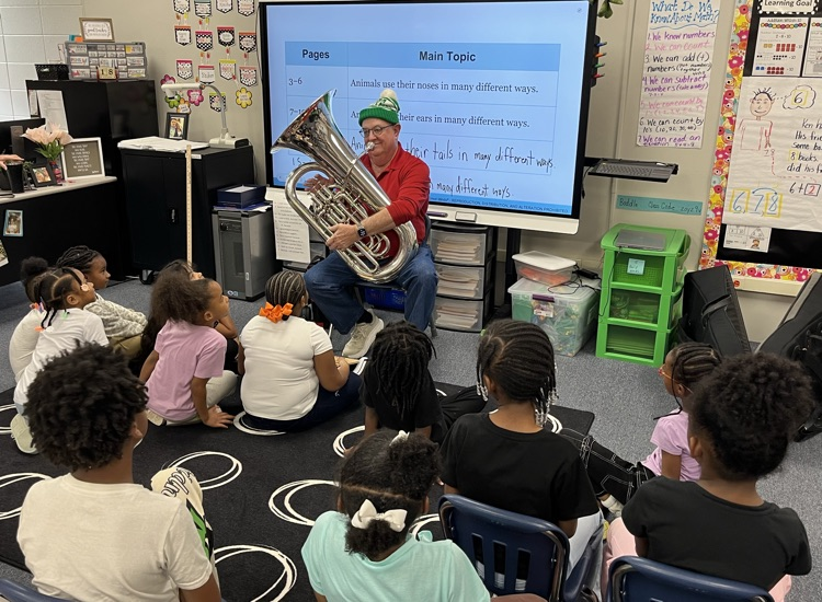 volunteer playing the tuna for a class of first graders