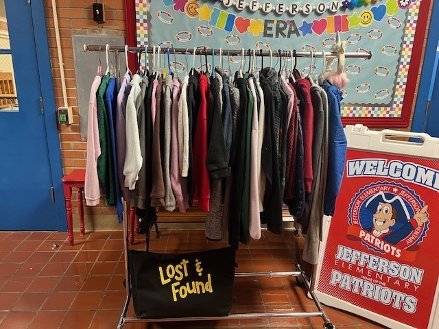Picture of kids' coats, sweaters, pullovers, and jackets hanging on a rack.