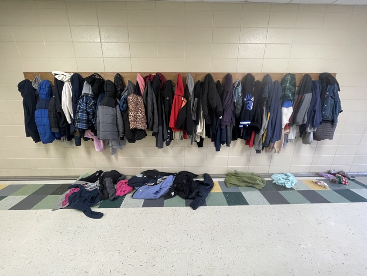 an overflowing coat frack filled with students jackets and coats