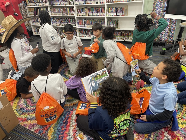 kids sitting at the carpet with their reading in the rock backpacks full of books
