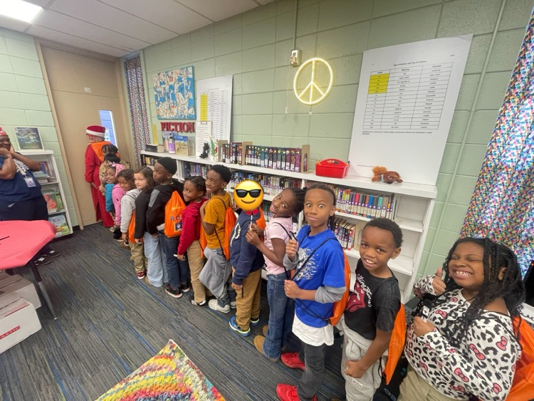 kids lined up with backpacks full of books from reading in the rock