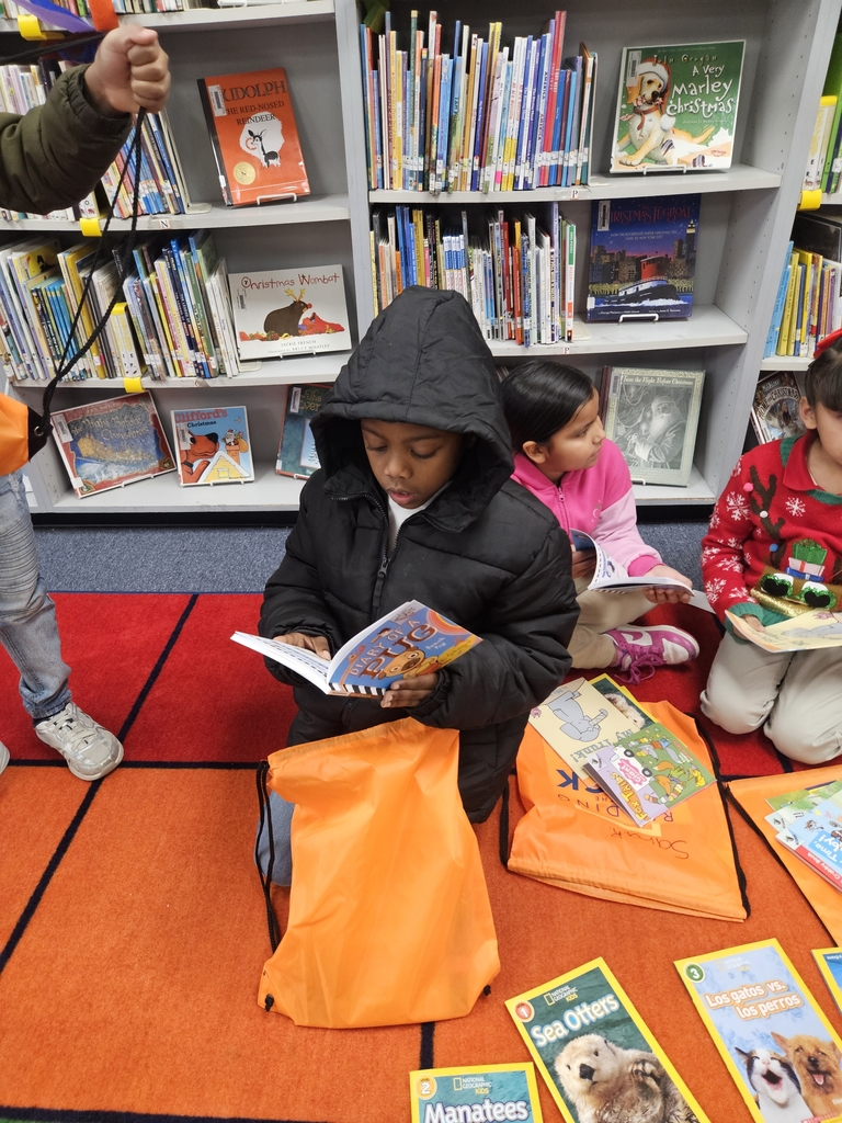 Image of students looking at new books received through the Readin in the Rock reading initiative 