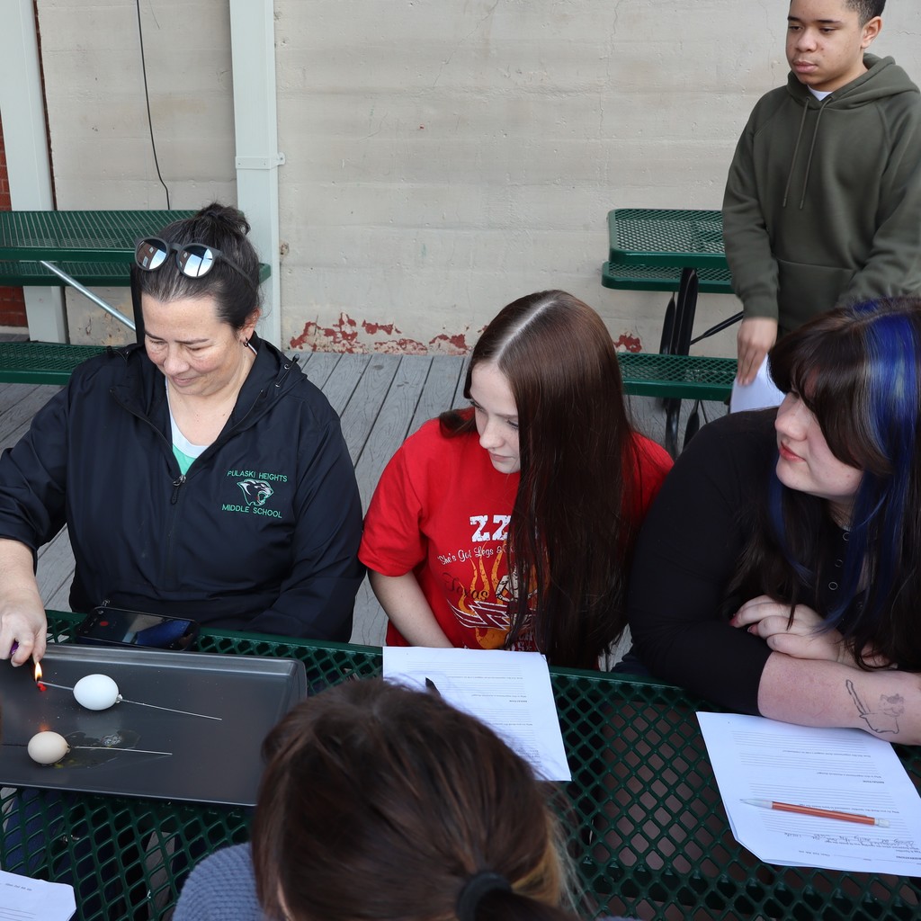 Students watching a sparkler and egg experiment.