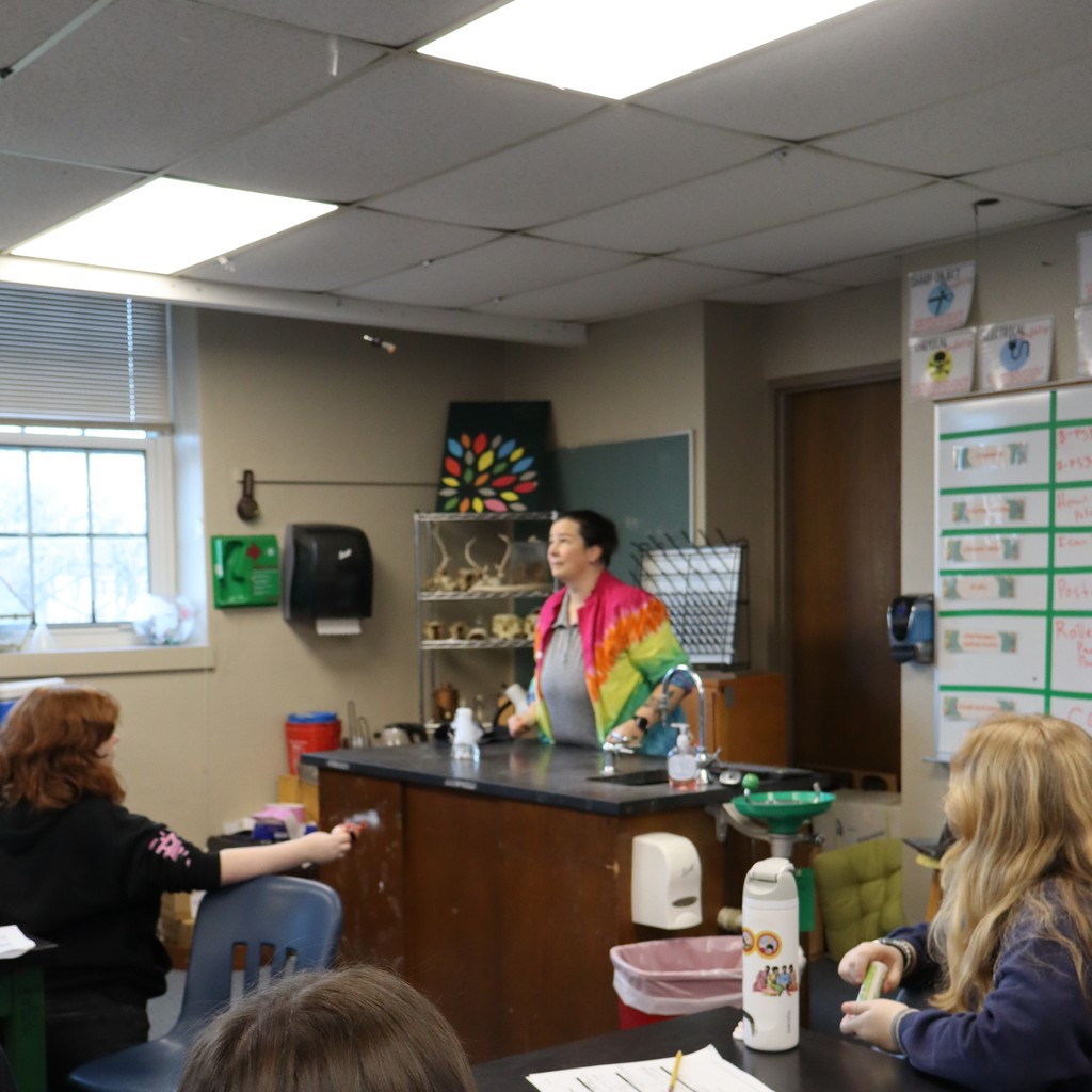 Students observing a chemical reaction causing a stopper to fly into the air.