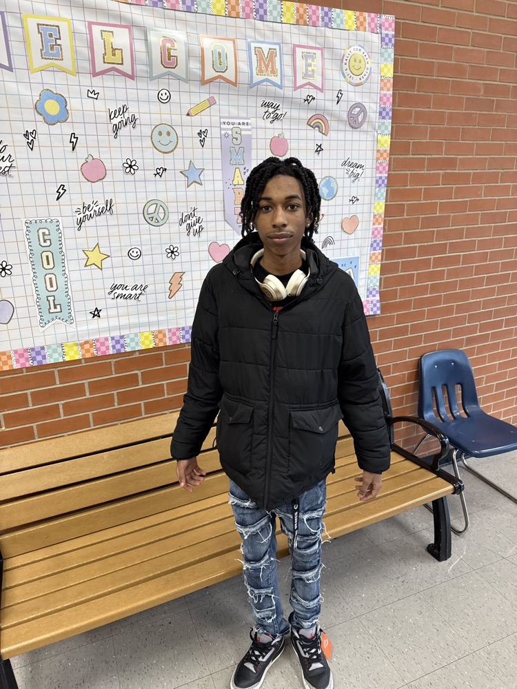 image of student with sign in background 