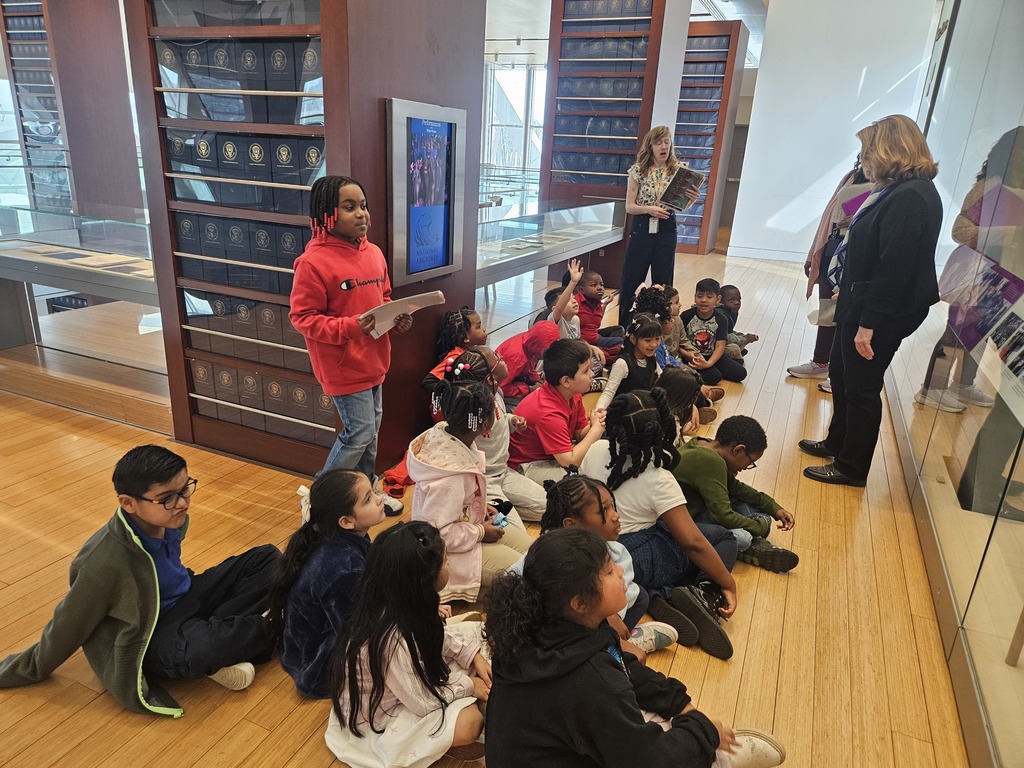 Students listening to the interpreter speak about the presidential collection on display.